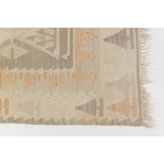 This is a vintage Turkish Oushak rug from the Mid 20th Century. The piece was hand-knotted.