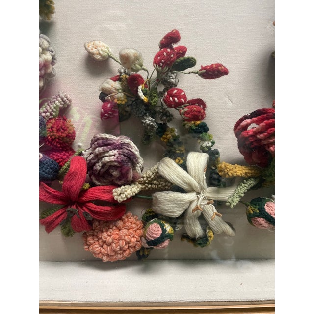 A Victorian floral folk art memorial wreath consisting of felt/wool/yarn flowers and birds in a deep gilt frame shadow...