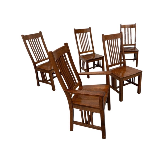 A handsome set of six vintage Mission-style oak dining chairs, American made circa 1990s, offering the substantial...