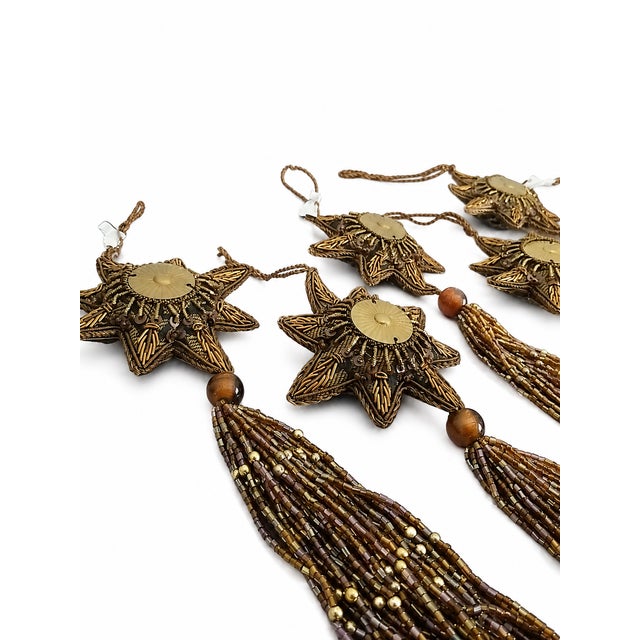 Elegant set of six decorative Christmas ornaments featuring dimensional eight-point starbursts in a rich antique-gold...