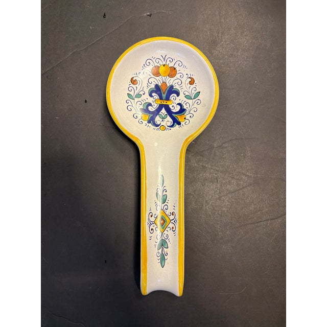 A refined hand-painted ceramic spoon rest by Nova Deruta, crafted in Italy and inspired by traditional Deruta majolica...