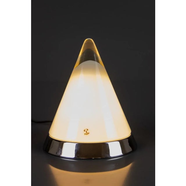 A Peill & Pulzer Kibo model table lamp. The pyramid-shaped lamp features a hand-blown clear and white shining opaline...