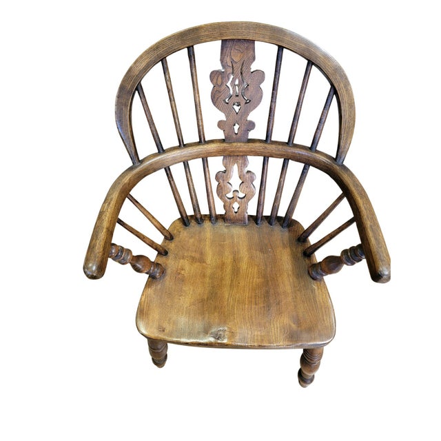A Childs Windsor chair made of Ash, with turned legs and arm posts and a Crinoline stretcher typical of the type of chair...