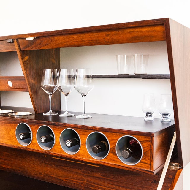 A newly restored and timelessly chic floating rosewood dry bar by Erik Buck, produced in Denmark by Dyrlund c. mid 1960s....