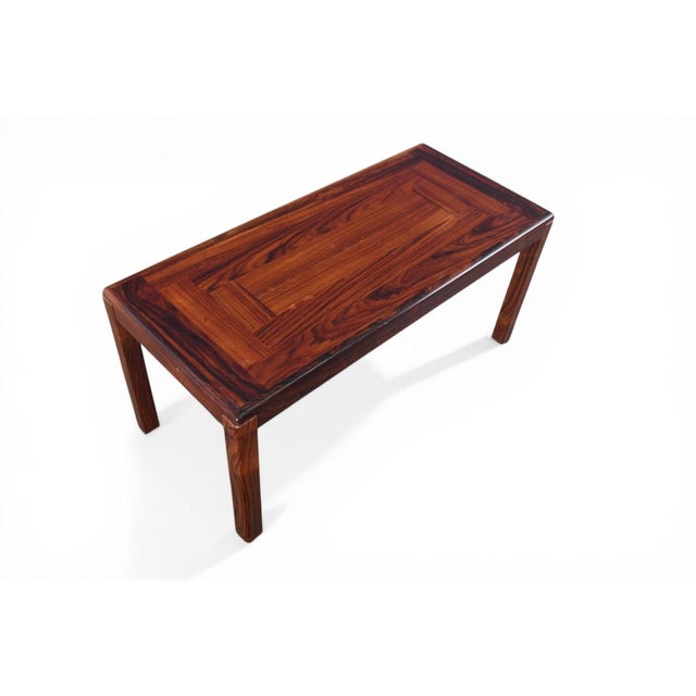 A sleek rectangular coffee table in richly grained rosewood, produced by Vejle Stole Møbelfabrik in Denmark during the...