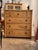 A handsome English pine chest of drawers in a warm honey tone, the rounded top above a bank of five small drawers over...