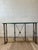 A refined Hollywood Regency console table dating to the 1970s, featuring a polished brass frame with elegant turned...
