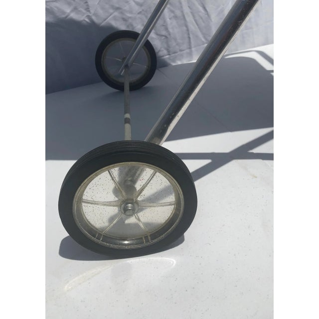 Wonderful, useful 1950s folding bar cart in aluminum with wood grain melamine top, and two confetti lucite wheels, light...