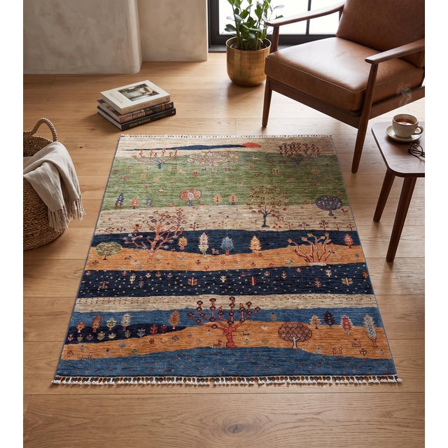 A hand-knotted rug in the Persian Gabbeh style, built up as a landscape in sage green, gold, indigo and cream. Hand-spun...