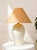 A beautifully understated vintage table lamp featuring a substantial white sculptural base with a softly rounded,...