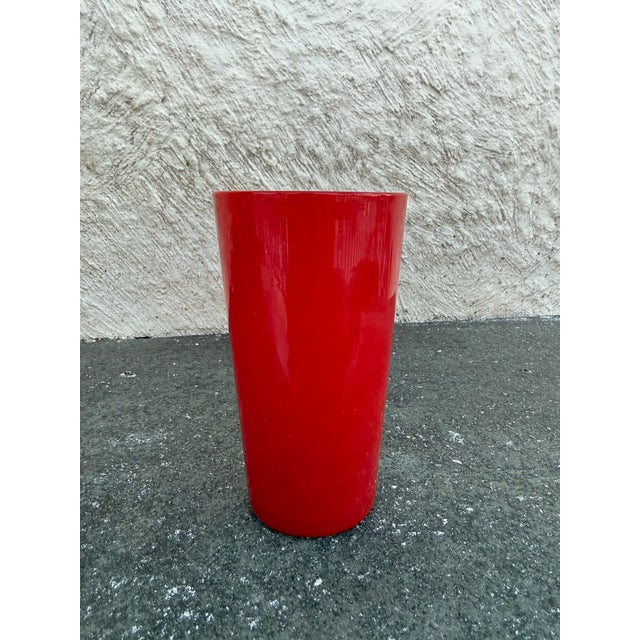 Pair of red opaque thin wall highball glasses. They are unmarked.