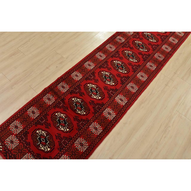 An authentic vintage tribal Turkmen runner, hand-knotted with fine wool and natural dyes. This nomadic rug features a row...