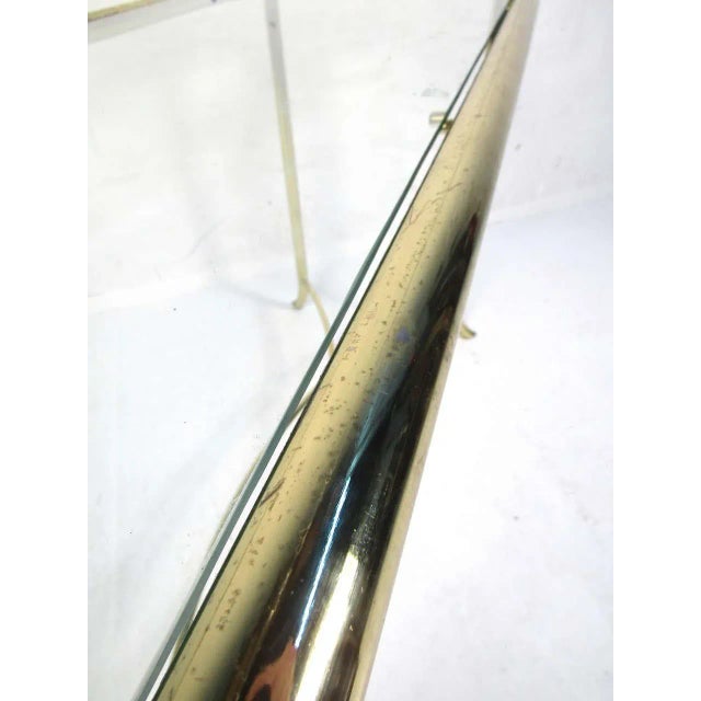 Stylish mid-century style console table. Brass colored frame with a glass insert serving as the tabletop. WEAR Wear...