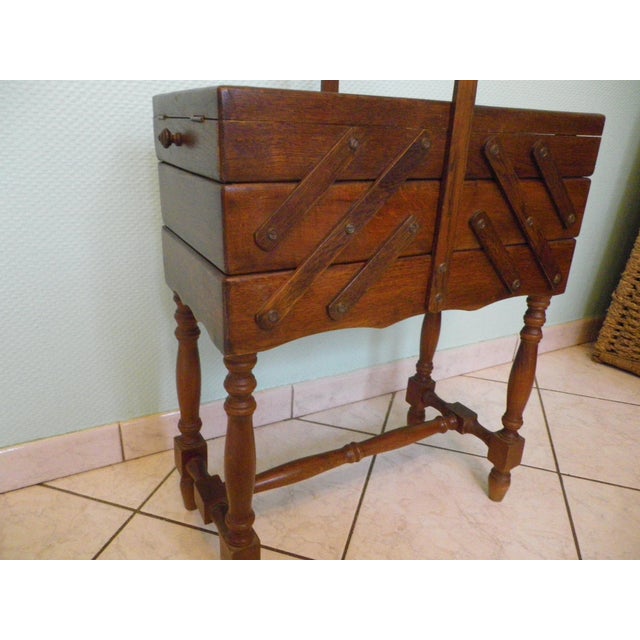 Large wooden sewing box on a stand, dating from the 1950s/60s, with a carrying handle. It extends like an accordion to...