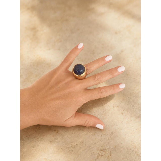 A substantial 1970s Modernist bombé ring crafted in polished 14K yellow gold and set with an impressive lapis lazuli...