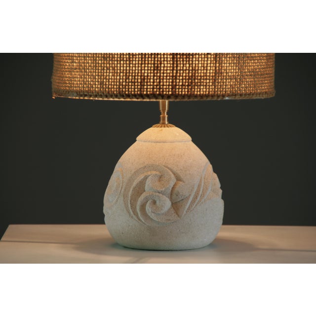 Elegant and sculptural, this reconstituted stone lamp captivates with its rounded shape and delicately engraved relief...