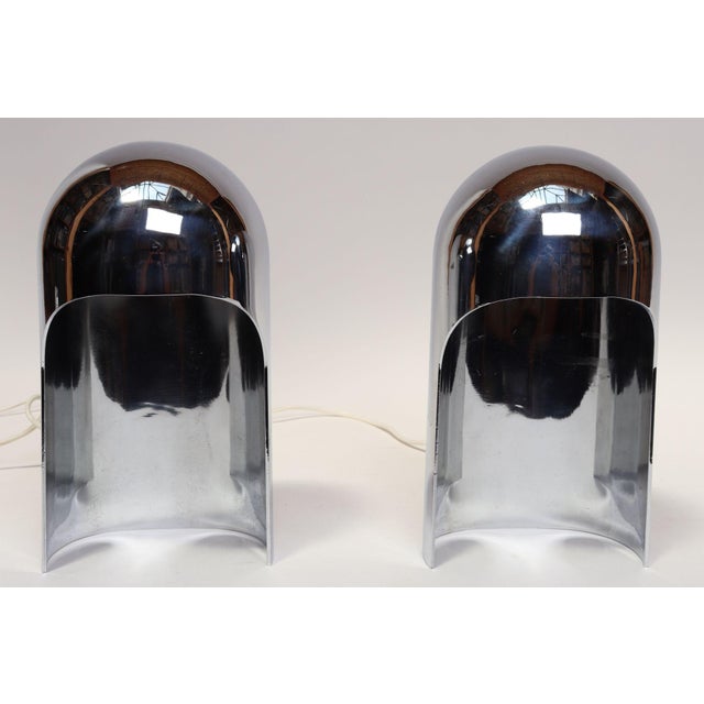 Striking pair of hooded/helmet-form table lamps in chrome with porcelain sockets (ca. 1960s, Italy). Sculpturally elegant,...