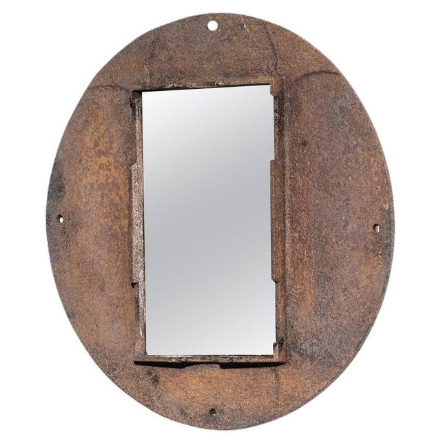 An iron mirror from 1920s France. An interplay of shapes and textures creates a weathered industrial aesthetic: a...
