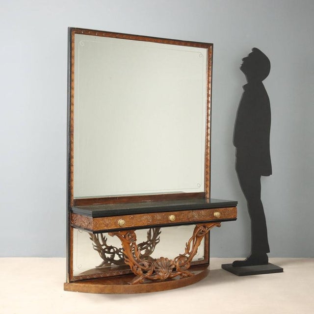 Console with mirror in walnut made in Italy in the mid-20th century, featuring a green serpentine marble top that adds a...