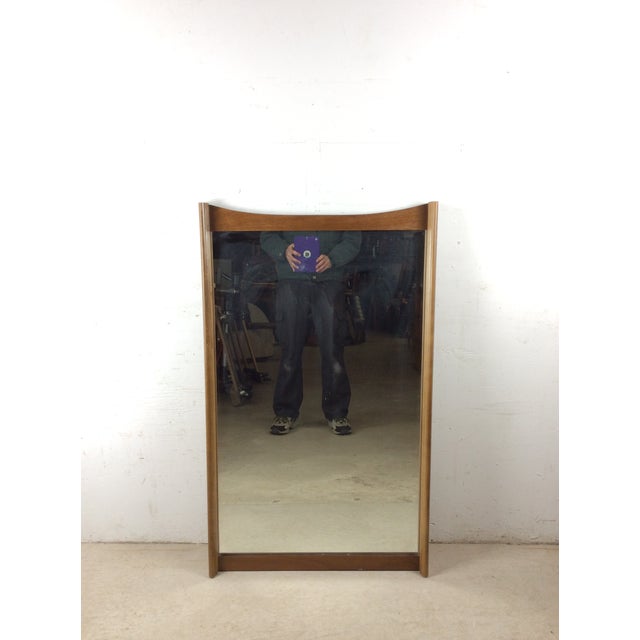 This mid century modern mirror features hardwood frame, original light walnut finish, unique curved wood top, and vintage...