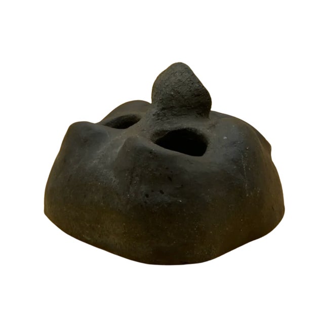 This striking hand-built clay mask showcases an expressive biomorphic form with fluid, sculptural contours and a bold...