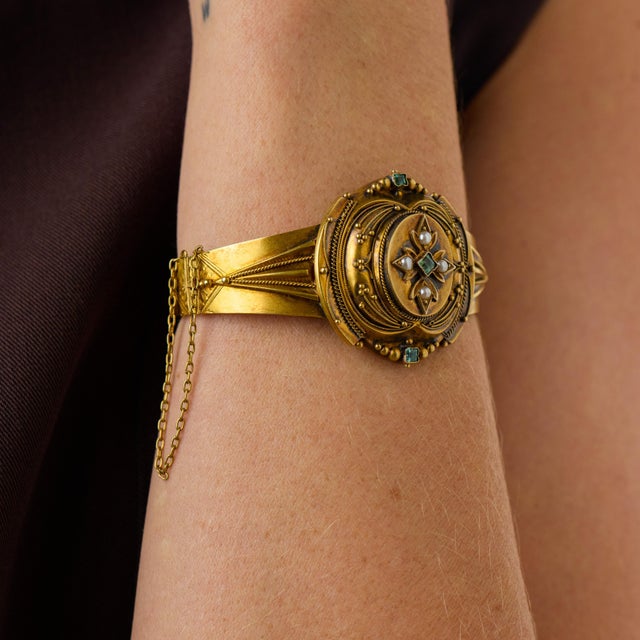 This elegant Victorian bangle is a beautifully refined jewel from the 1900’s, featuring 3 square cut emeralds arranged...