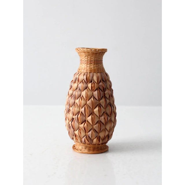 This is a vintage wicker wrapped vase. With a white ceramic center vase, a stunning basket weave encases the exterior with...