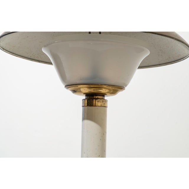 Table lamp made of brass in its natural color and white lacquered, and acrylic iglass. Brass shade in its natural color,...