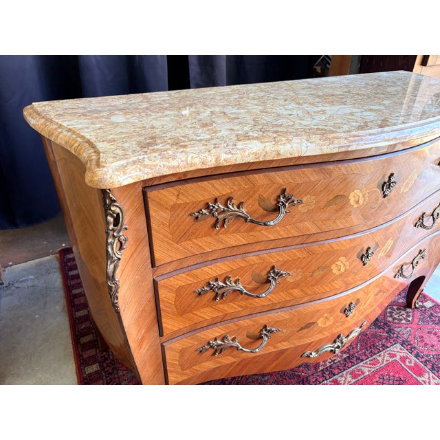 A very elegant french louis xv style commode, signed “marquant,” featuring three large drawers (with keys) in a curved...
