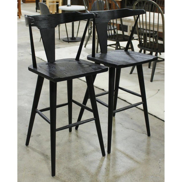 Crafted from black oak with a sculptural, Scandinavian-inspired silhouette, these barstools feature gently curved crest...