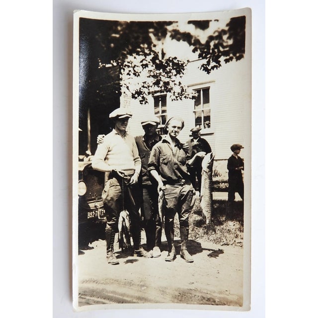 Early 20th century snapshot photograph of men and their fish. Unframed, corner bumps.