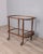 Bar trolley with wooden structure and clear glass shelves, bottle holder on the lower level and gilded brass handle,...
