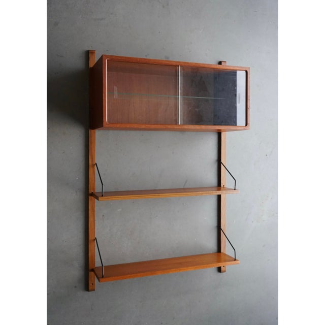 A small classic Cadovius shelving system with display cabinet. Composed of two 20cm deep shelves that can be attached at...