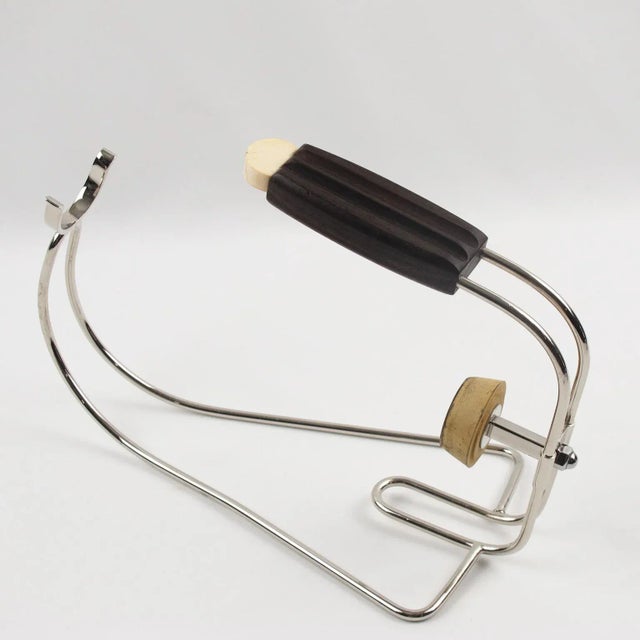 A striking French Art Deco chromed metal bottle holder, wine pourer, or server, designed by Jacques Adnet (1901 - 1984)....