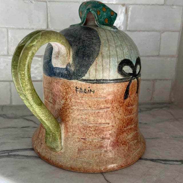 Vintage hand painted and signed Italian lady pitcher. Shows flower tree in front, green and orange dotted handkerchief and...