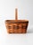 A vintage 1991 Longaberger handwoven market basket with warm honey-toned weaving accented by red and green bands along the...