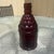 This is a vintage 1970s ruby red glass "McGiver's American Army Bitters" bottle produced by Wheaton Glass in Millville,...