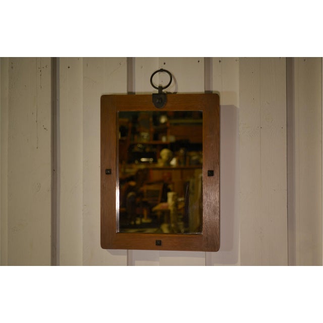 Brutalist wall mirror from the 1960s in solid oak, with softened corners and adorned with pyramidal metal nails. A large...