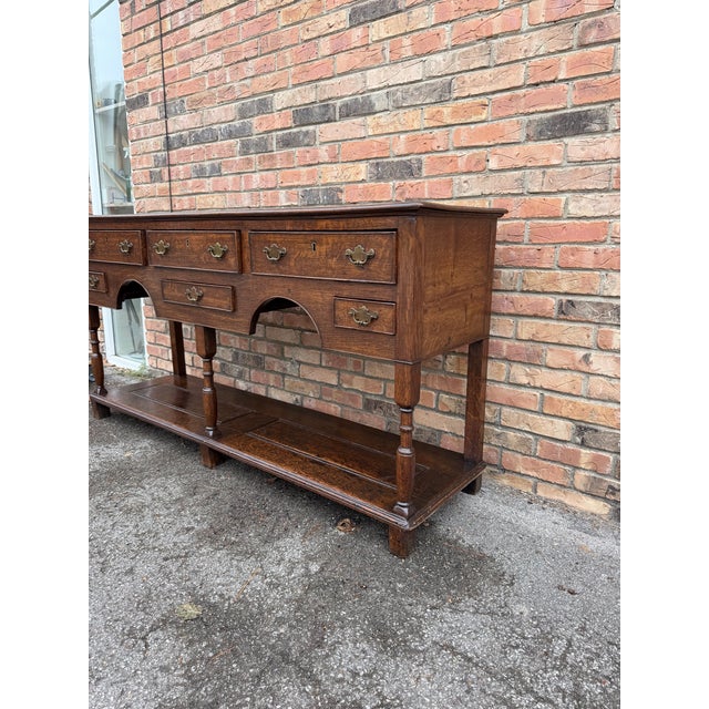 This is an attractive Welsh Dresser base with rectangular top over 6 drawers with elegant turned leg supports over...