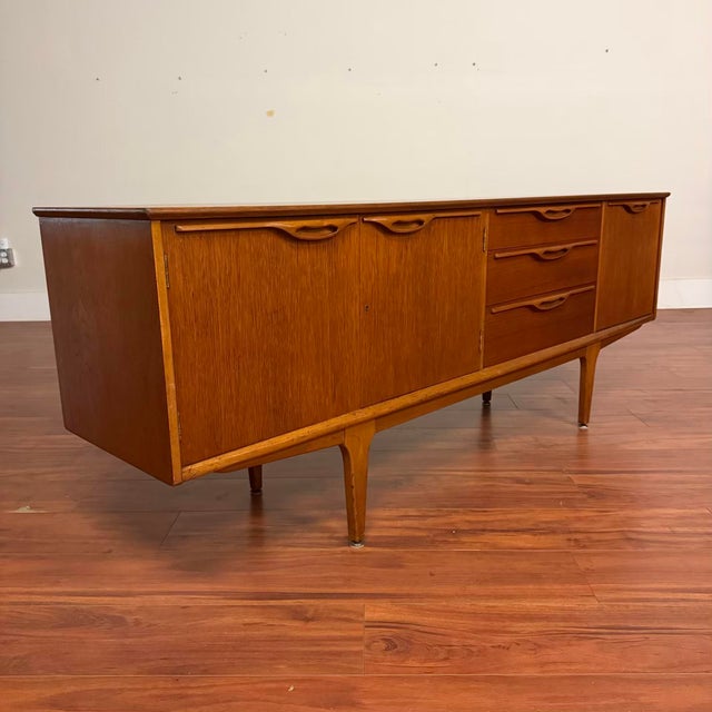 Vintage mid-century long teak sideboard bar made in the U.K. by Jentique circa 1960's. This piece features beautiful...