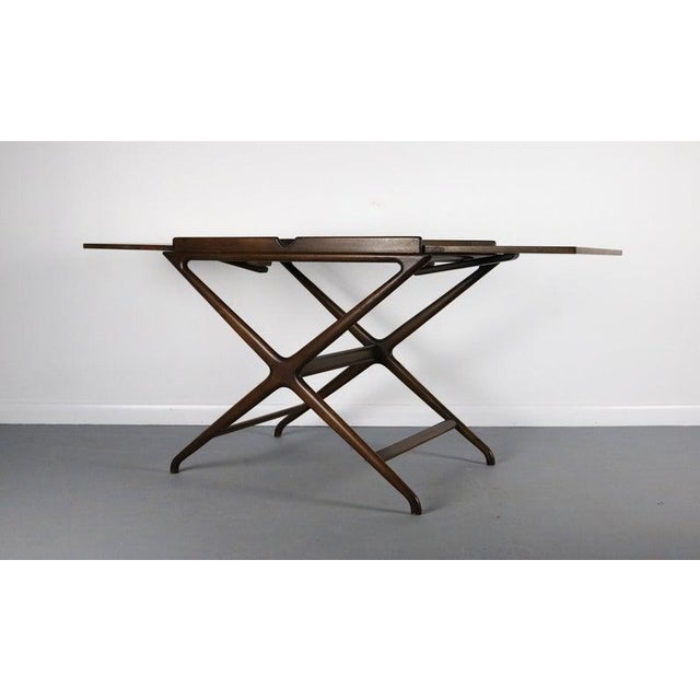 A stylish server / bar cart in walnut with exquisite sculpted legs. Designed by Cesare Lacca for Baker Furniture. A metal...