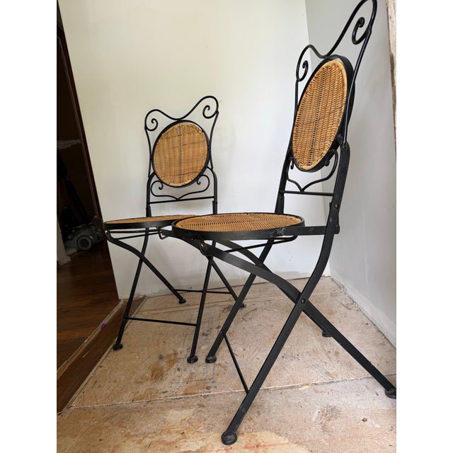 Pair of 1930s vintage French wrought iron and wicker folding chairs. Ideal for a bistro table. The wicker is in great...