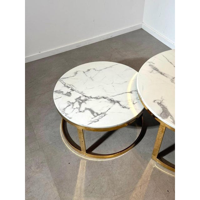 Elegant set of two round nesting coffee tables featuring white marble style tops with distinctive grey veining, combined...