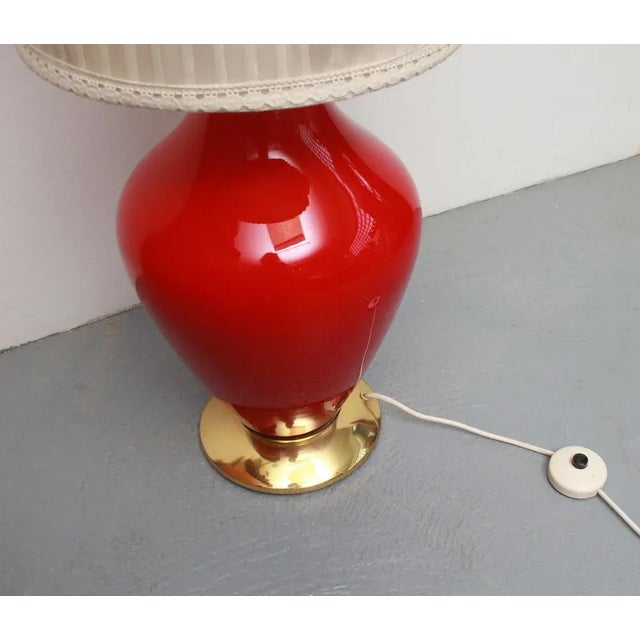 50s floor lamp. Heavy glass base made of bright red high -gloss glass with brass ring. Textile lampshade in light...