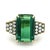 A dramatic 1970s cocktail ring centered by a monumental emerald-cut green tourmaline weighing approximately 10 carats. The...