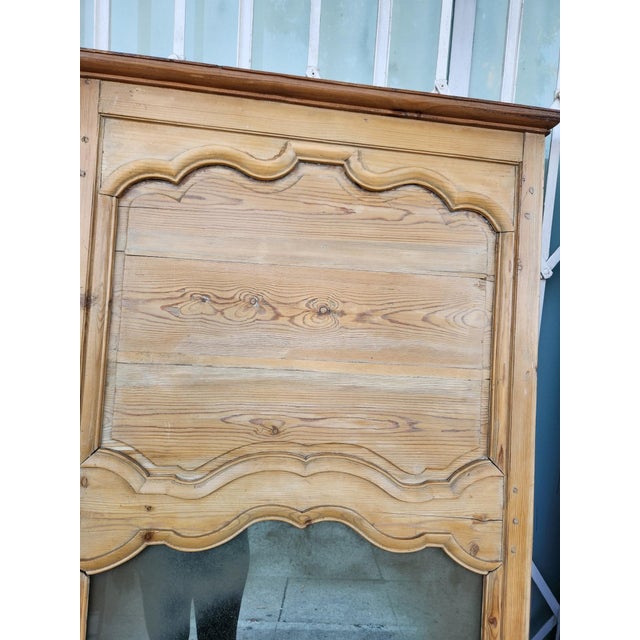Antique pair of floor-length mirrors constructed from solid pine wood. Each piece has a natural light wood finish with...