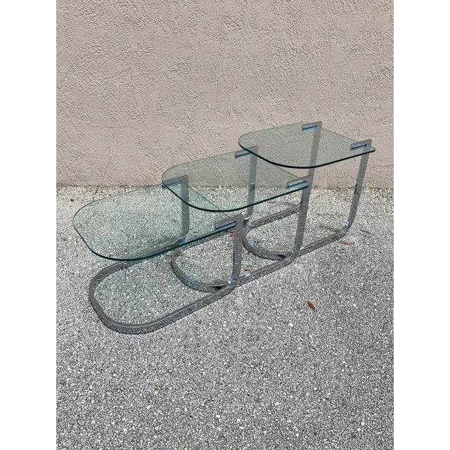 A set of 3 chrome and glass nesting tables by Design Institute of America. Clean and flowing design that looks good...