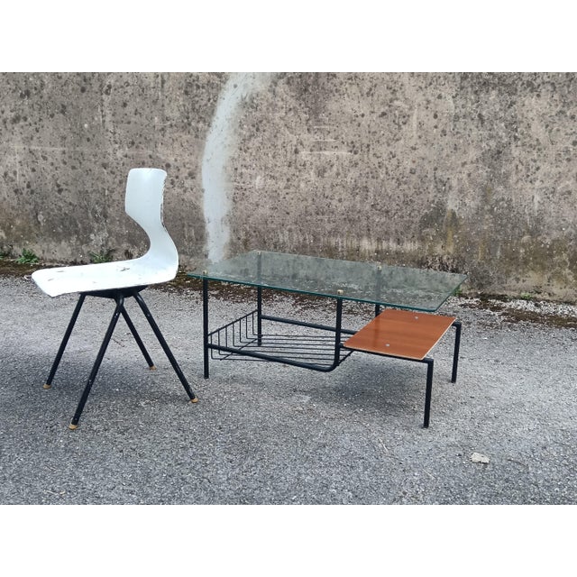 Small coffee table with a wooden shelf and magazine rack. Thick tempered glass top, steel tube base.