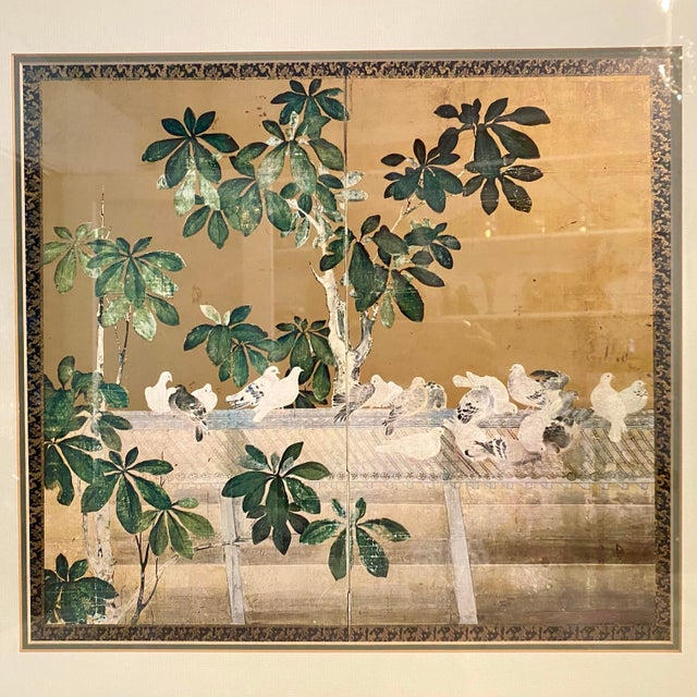 The artwork features a gold leaf or gold-painted background with flock of white and grey pigeons , resting on a roof among...