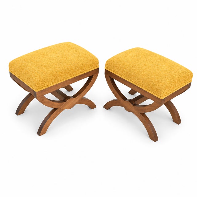 A handsome pair of Tuscan-style ottomans featuring sculptural, curved X-form bases in a warm medium walnut finish. The...